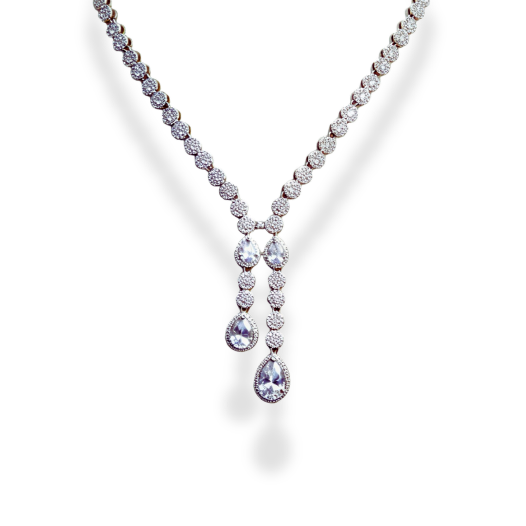 American Diamond Teardrop Set, A dazzling ensemble tailored for cocktail nights, formal galas, weddings, or high-profile celebrations. This refined set adds an air of glamour to evening gowns, sarees, or chic contemporary outfits. Whether you're attending a reception or walking into a luxurious dinner party, its brilliance ensures you remain the center of attention with effortless grace. Material & Care Material: Gold Alloy, sterling silver, silver, brass, aluminium Plating: Silver Plating Stones: AAA-Grade