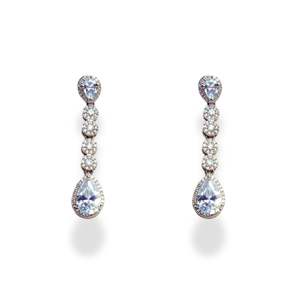 American Diamond Teardrop Set, A dazzling ensemble tailored for cocktail nights, formal galas, weddings, or high-profile celebrations. This refined set adds an air of glamour to evening gowns, sarees, or chic contemporary outfits. Whether you're attending a reception or walking into a luxurious dinner party, its brilliance ensures you remain the center of attention with effortless grace. Material & Care Material: Gold Alloy, sterling silver, silver, brass, aluminium Plating: Silver Plating Stones: AAA-Grade
